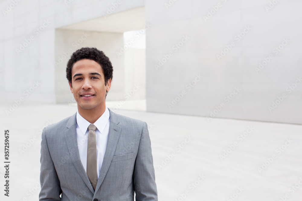 Portrait of smiling businessman standing outside cultural center Portrait of smiling businessman standing outside cultural center