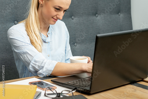Young woman is using laptop during online learning at home office.