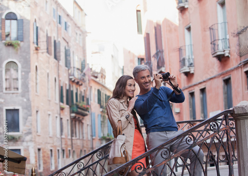 Smiling couple taking photograph in Venice