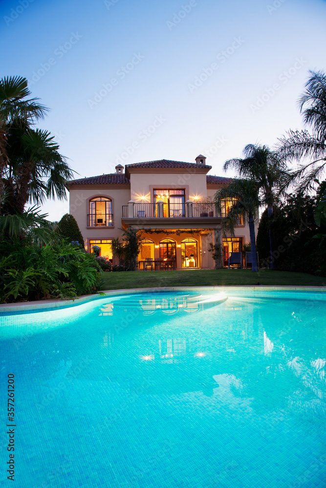 Luxury swimming pool and villa at dusk