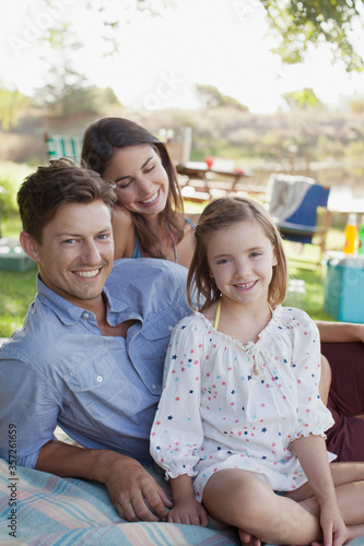 Portrait of smiling family picnicking at lakeside