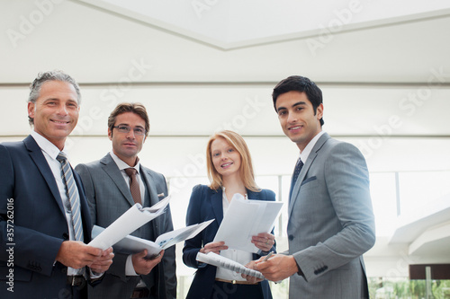 Portrait of smiling business people reviewing paperwork