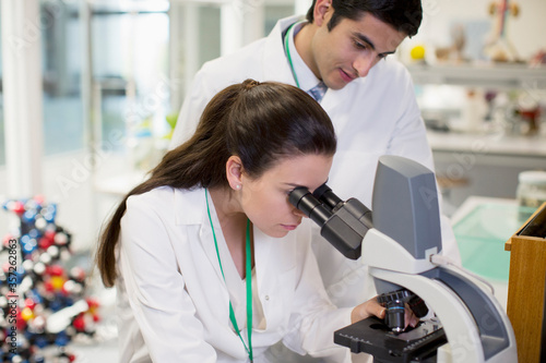 Scientists using microscope in laboratory