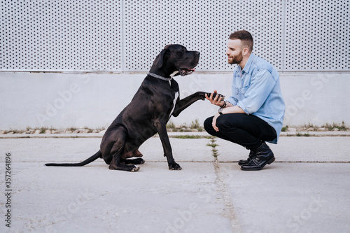 Young man teaching his dog outdoors