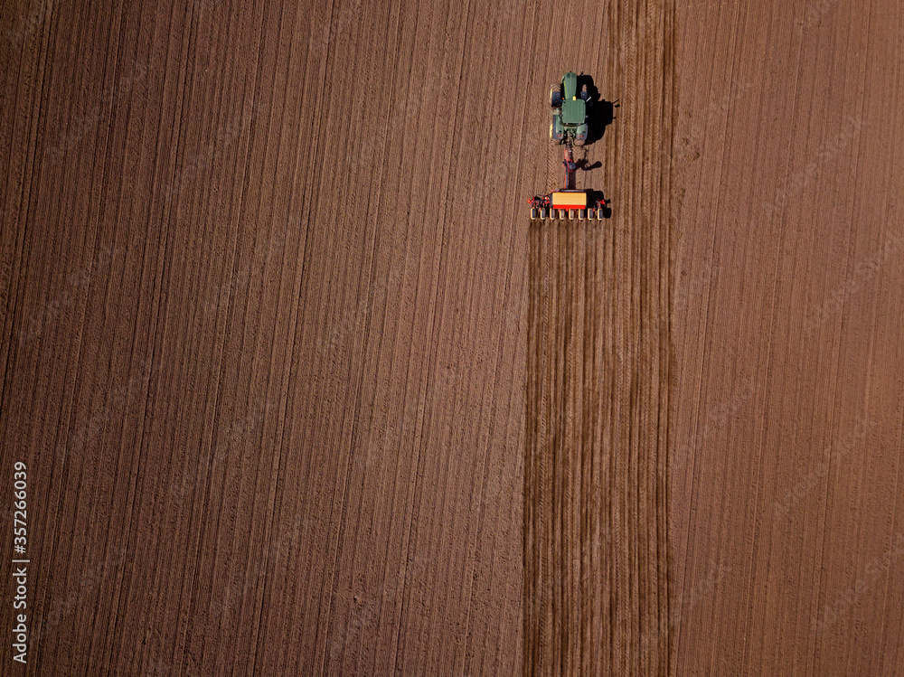 Russia, Aerial view of tractor plowing brown field Russia, Aerial view of tractor plowing brown field