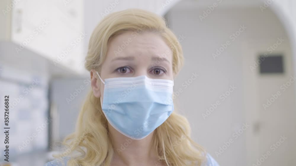 Crying young female in mask looking at camera, scared of dangerous disease Crying young female in mask looking at camera, scared of dangerous disease