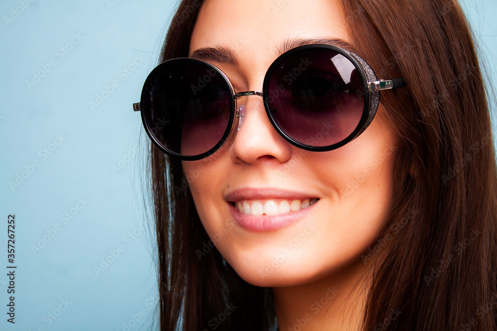 Photo of a girl in sunglasses on the background. Young woman in glasses smiling. Photo of a girl in sunglasses on the background. Young woman in glasses smiling.