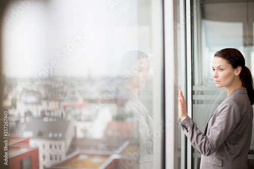 Canvas-taulu Businesswoman standing at office window