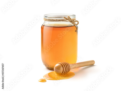 Glass Jar of pure honey with honey dipper isolated on white background.