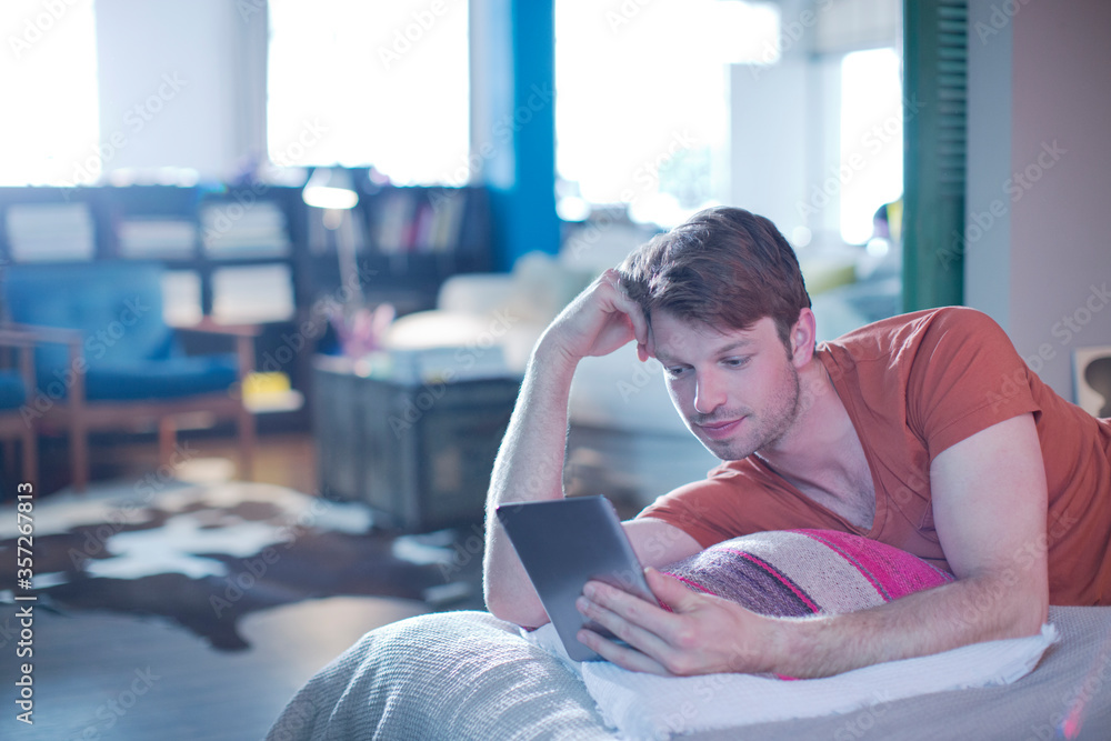 Man using digital tablet on bed Man using digital tablet on bed