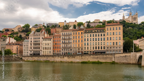 Vieux-Lyon, colorful houses in the center, on the river Saone, with the Fourviere cathedral in background 