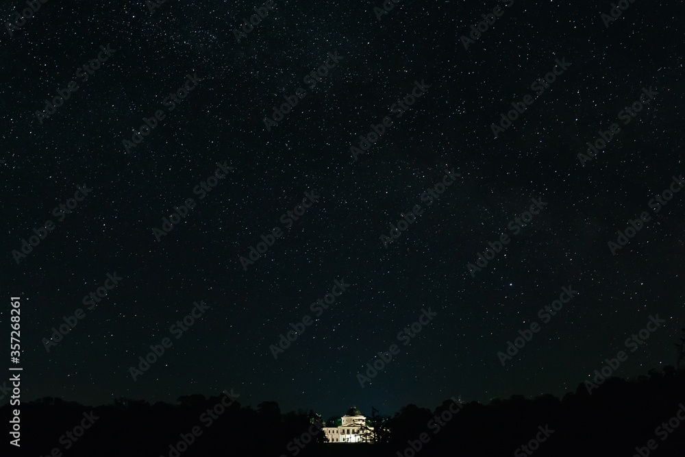White palace among the trees on the background of the starry night. Starry night White palace among the trees on the background of the starry night. Starry night
