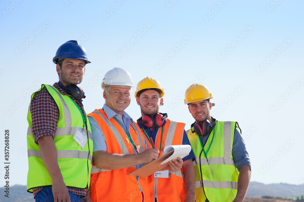 Businessman and workers smiling on site Businessman and workers smiling on site