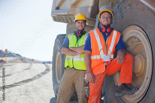 Vászonkép Workers leaning on machinery on site