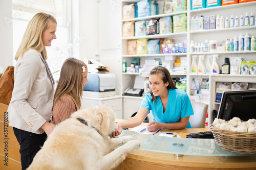 Receptionist greeting dog in vet's surgery photo