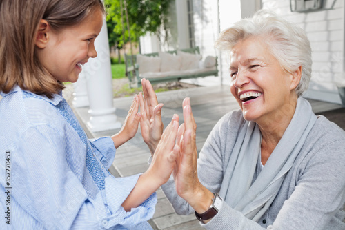 Woman and granddaughter playing clapping game photo