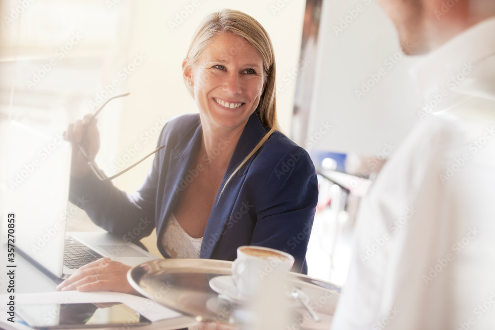 © Sam Edwards/KOTO - Businesswoman smiling at waiter in restaurant