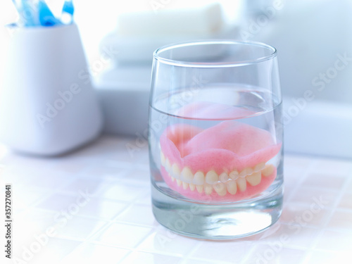 Close up of dentures soaking in glass of water