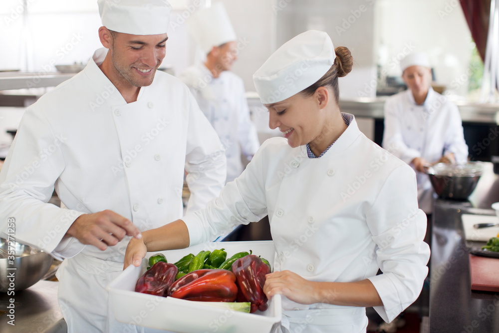 Chefs examining vegetables in restaurant kitchen Chefs examining vegetables in restaurant kitchen