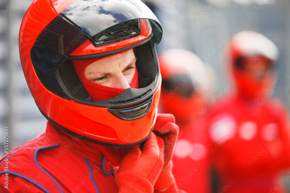 Racer tying on helmet on track