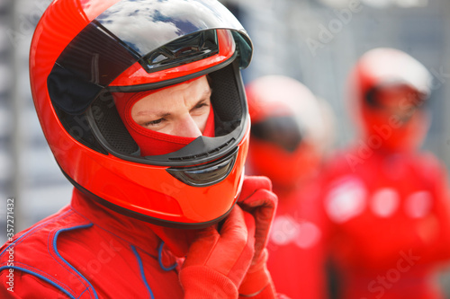 Racer tying on helmet on track