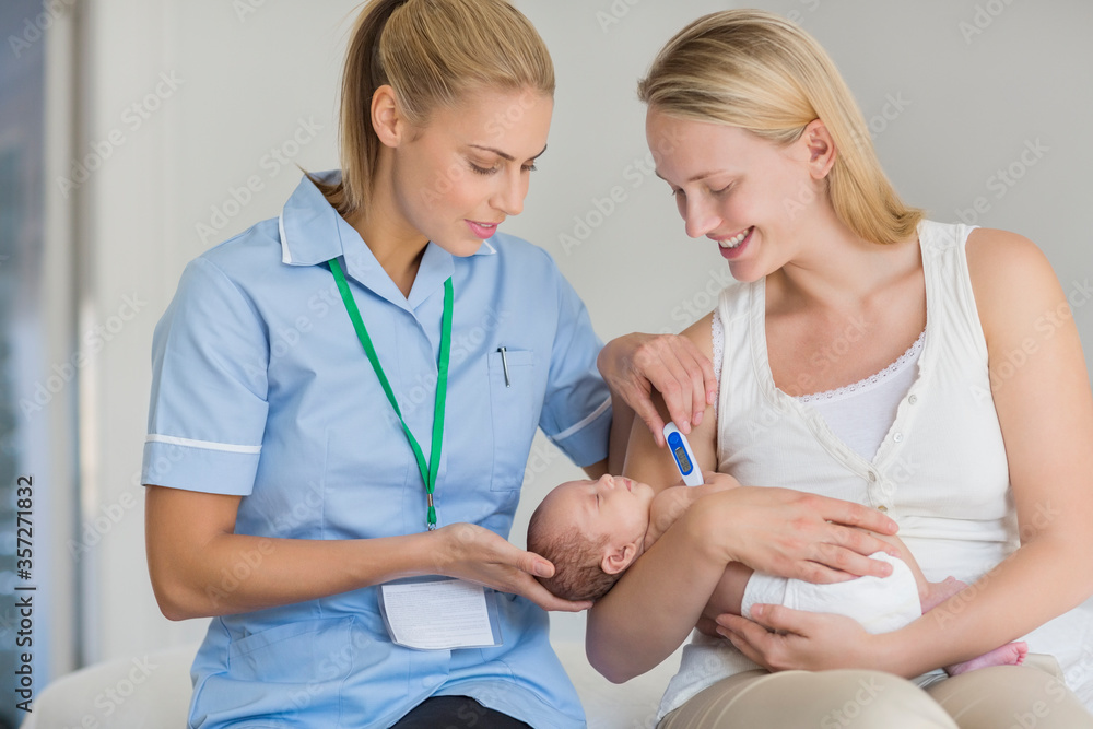 Mother and nurse taking newborn baby's temperature Mother and nurse taking newborn baby's temperature