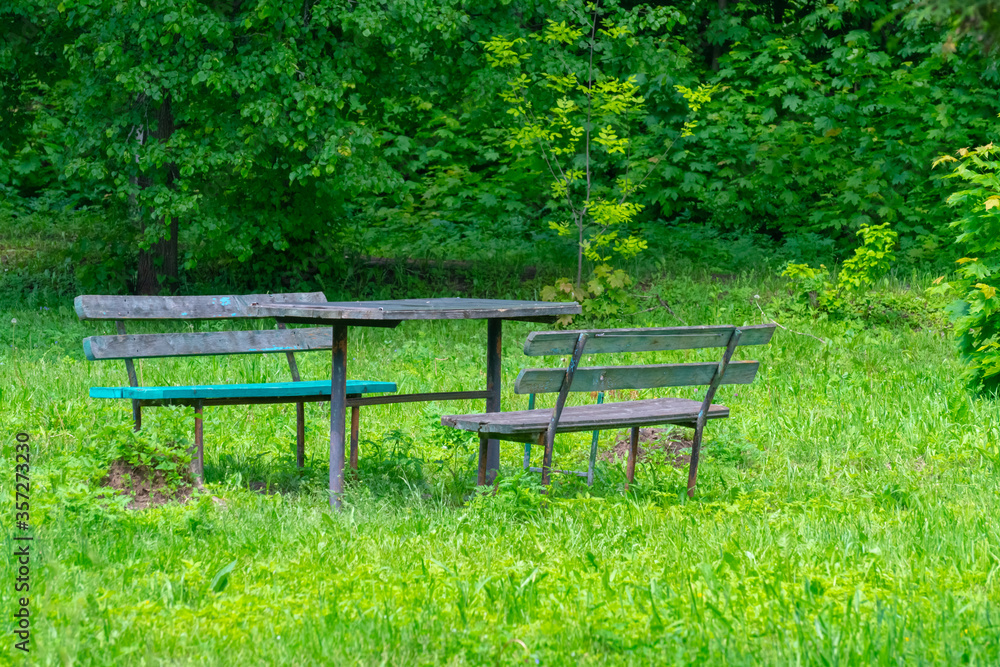 Old and dilapidated benches and table in an abandoned park Old and dilapidated benches and table in an abandoned park