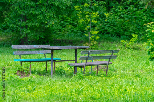 Old and dilapidated benches and table in an abandoned park