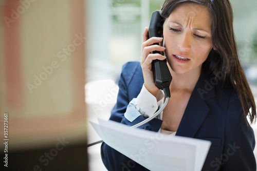Fotografie Businesswoman talking on phone in office