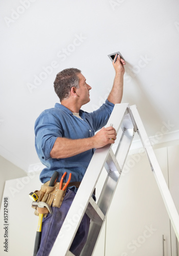 Electrician working on ceiling lights