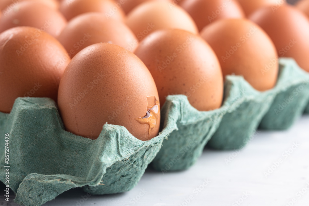 Broken egg inside the egg carton. Top view Broken egg inside the egg carton. Top view