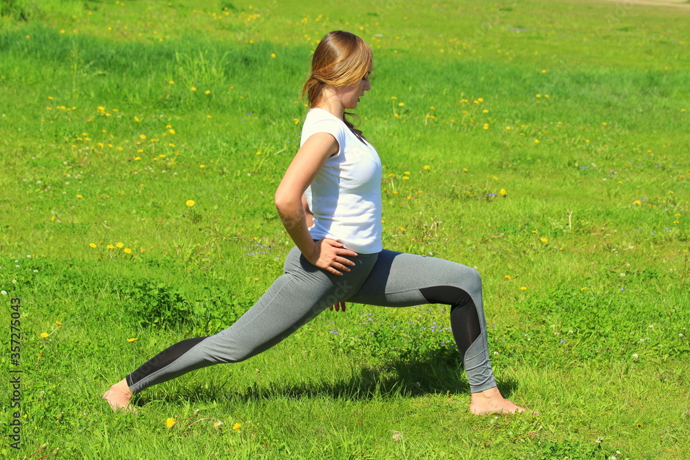 Young woman of European appearance does yoga in summer nature Young woman of European appearance does yoga in summer nature