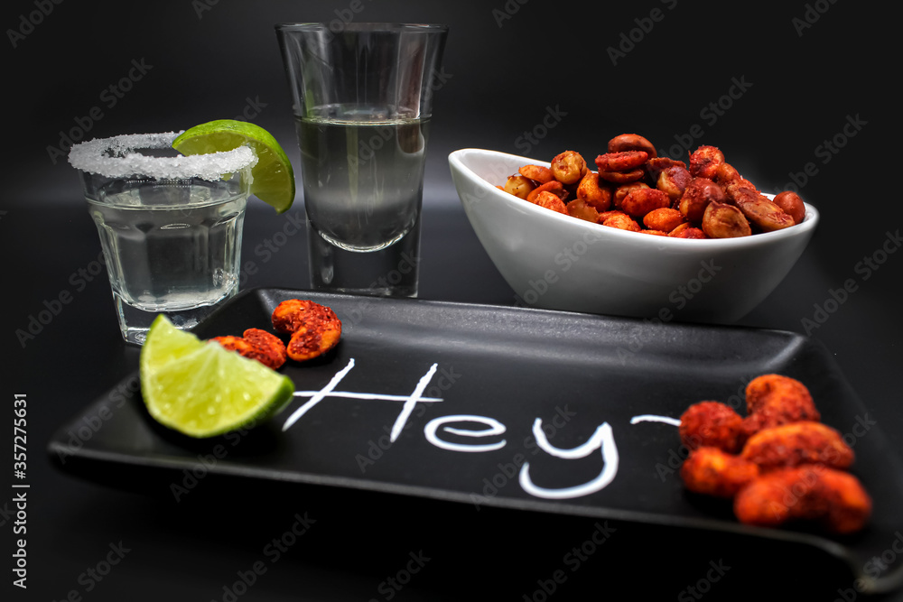 Caballito shot de tequila con cacahuates enchilados fondo negro