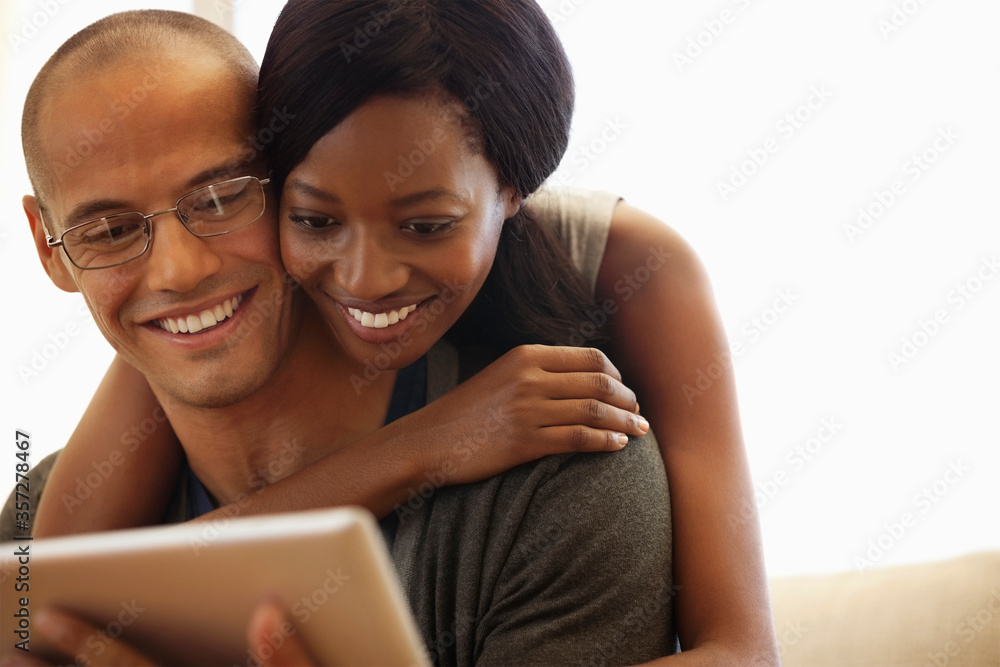 Couple using tablet computer on sofa Couple using tablet computer on sofa