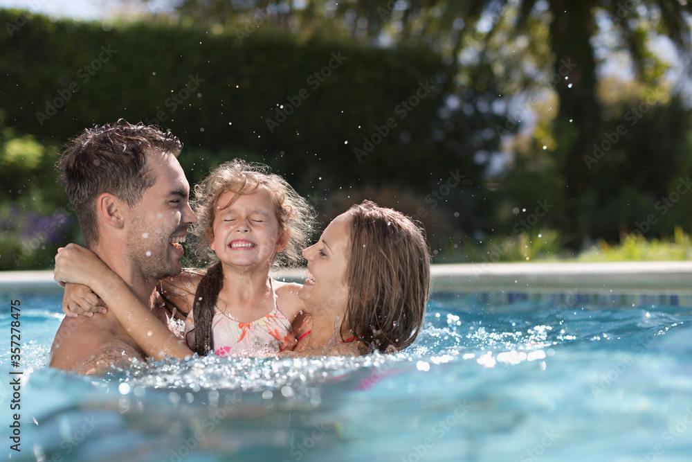 Family playing in swimming pool Family playing in swimming pool
