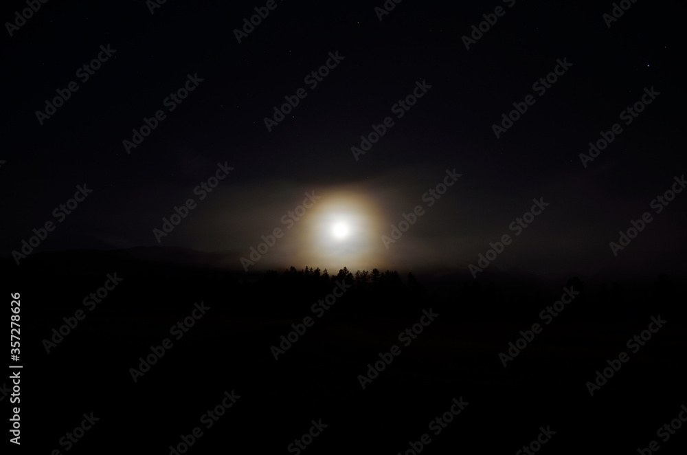 dreamy full moon night sky over spruce tree forest and mountain in autumn dreamy full moon night sky over spruce tree forest and mountain in autumn
