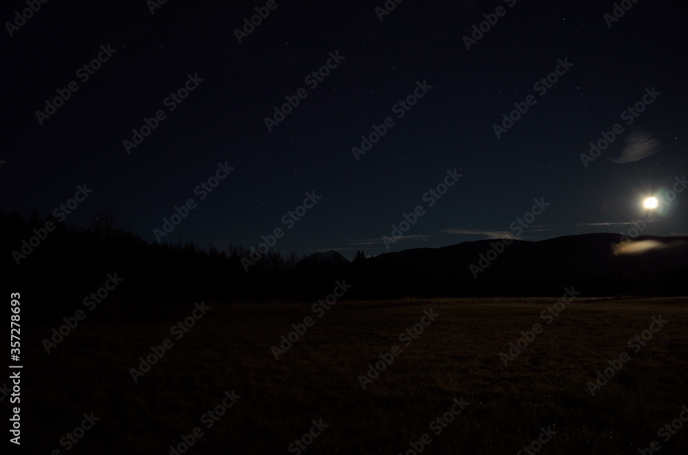 full moon over field and mountain in autumn night full moon over field and mountain in autumn night