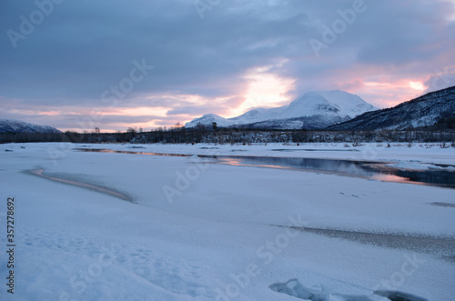 frozen river landscape with sunny pink glow and reflection © Arcticphotoworks