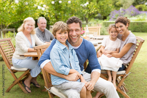 Family smiling at table outdoors