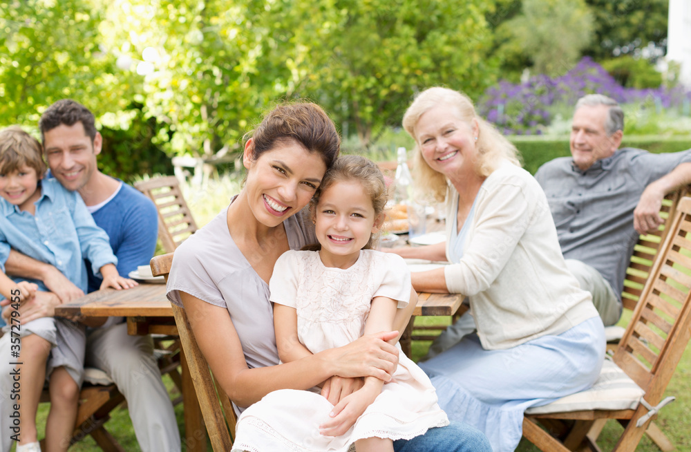 Family smiling at table outdoors Family smiling at table outdoors