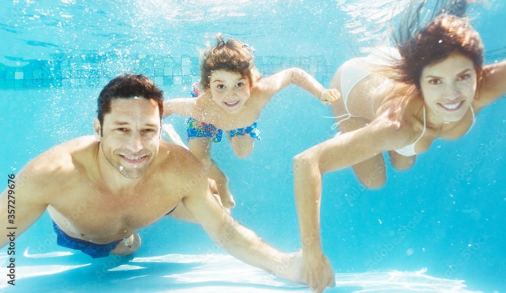Family swimming in pool