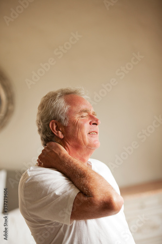 Senior man holding neck in pain