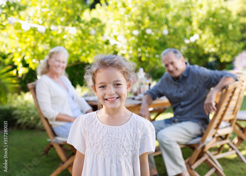 Girl smiling in backyard with grandparents © Chris Ryan/KOTO