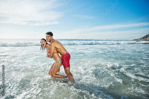 Enthusiastic couple hugging and splashing in ocean © Dan Dalton/KOTO