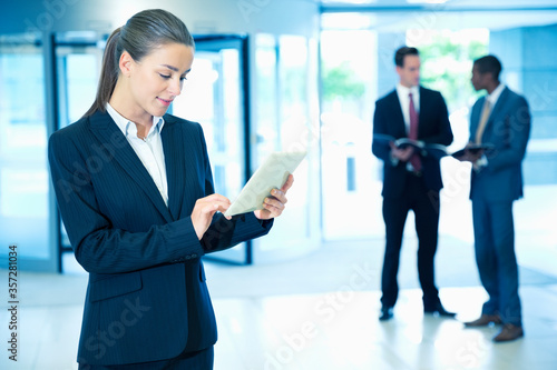Businesswoman using digital tablet in lobby photo