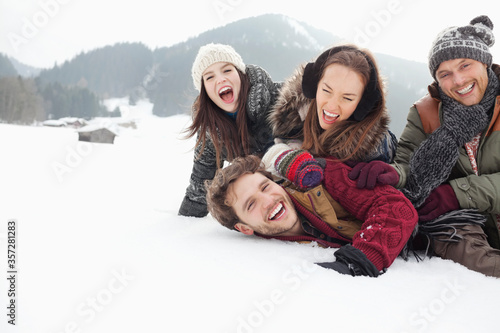 Playful friends laying in snowy field © Sam Edwards/KOTO