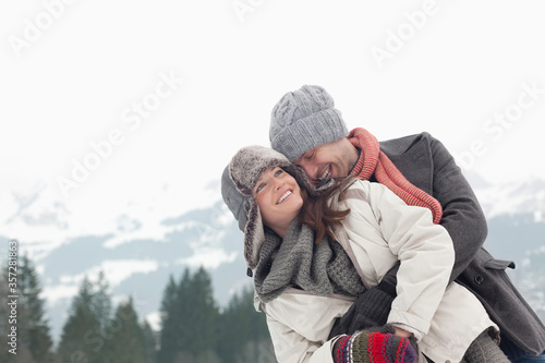 Happy couple hugging with mountains in background
