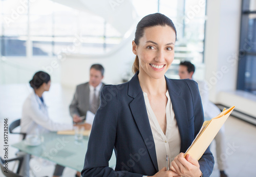 Portrait of smiling businesswoman in meeting with doctors