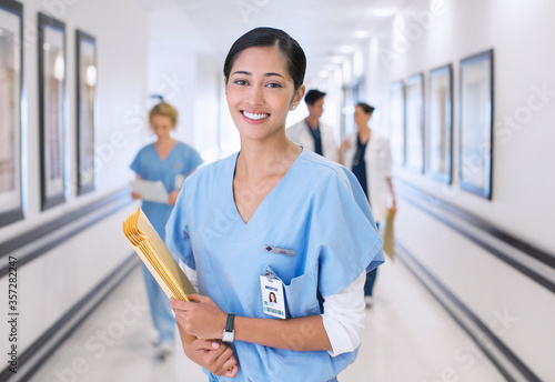 Foto Portrait of smiling nurse in hospital corridor