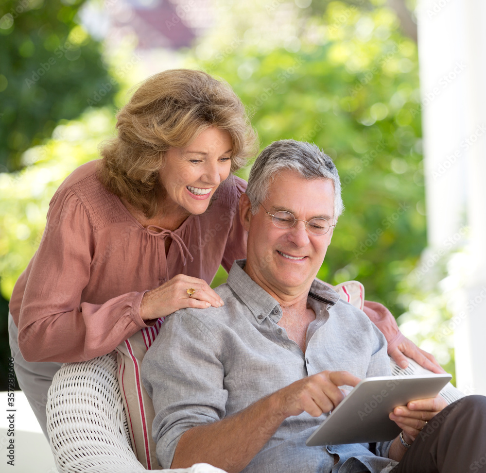 Senior couple using digital tablet on patio